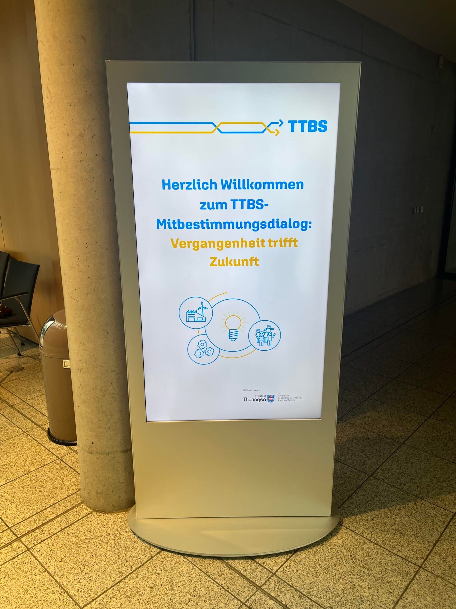 Innovative digital Anzeigetafel für TTBS Thüringen, begrüßt Besucher zum Mitbestimmungsdialog.