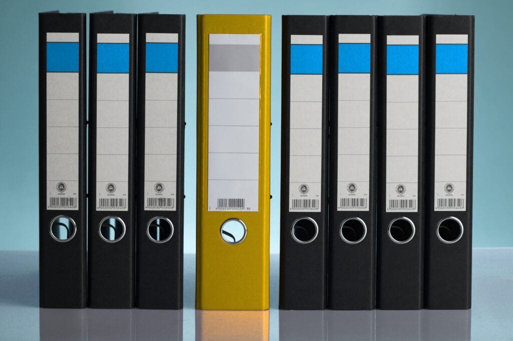 Ordnerregal mit Aktenordnern, symbolisiert Organisation und Büroarbeit.