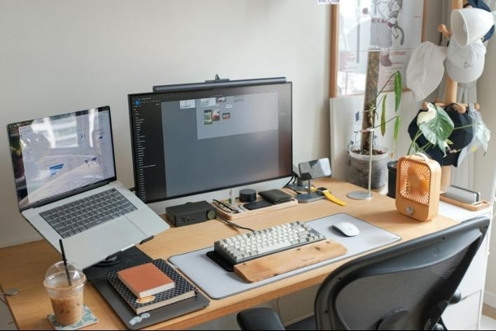 Modern Homeoffice mit Laptop, Monitor und Pflanzen für produktives Arbeiten.