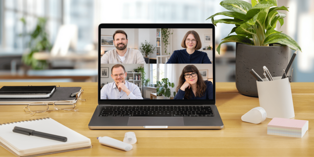 Virtuelles Meeting mit vier Teilnehmern auf Laptop-Bildschirm.
